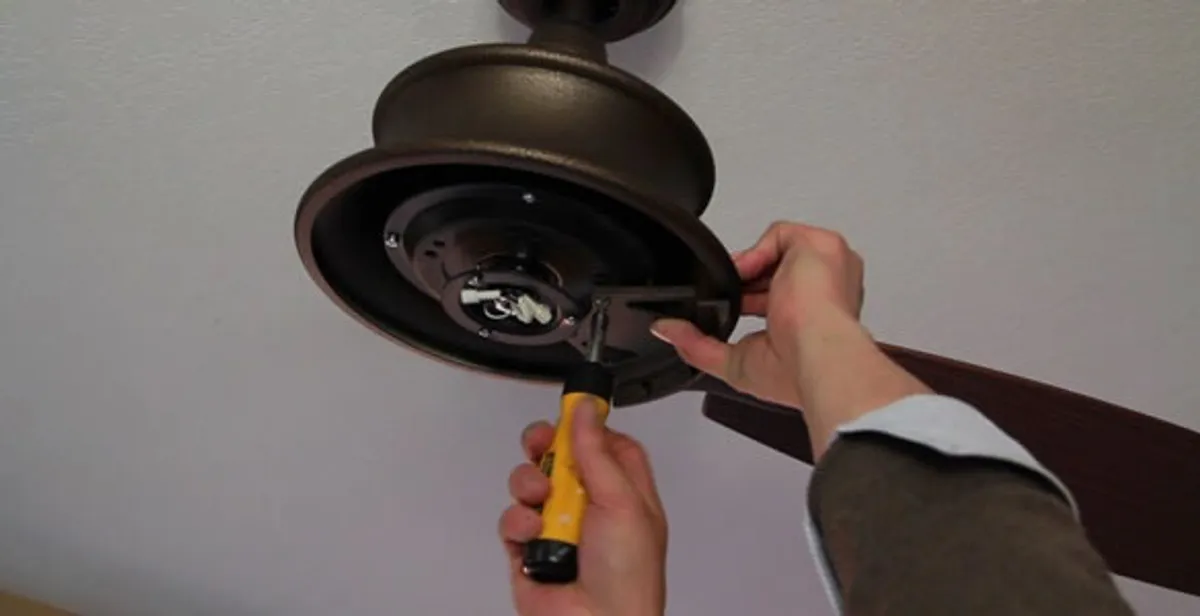 Electrician installing ceiling fan mounting bracket and fixture in Nashville, TN