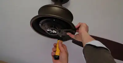 Electrician installing ceiling fan mounting bracket and fixture in Nashville, TN