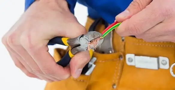 licensed electrician securing electrical wiring with professional tools during service work in Nashville, TN
