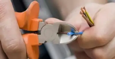 licensed electrician performing precise wire cutting and preparation during electrical service in Nashville, TN