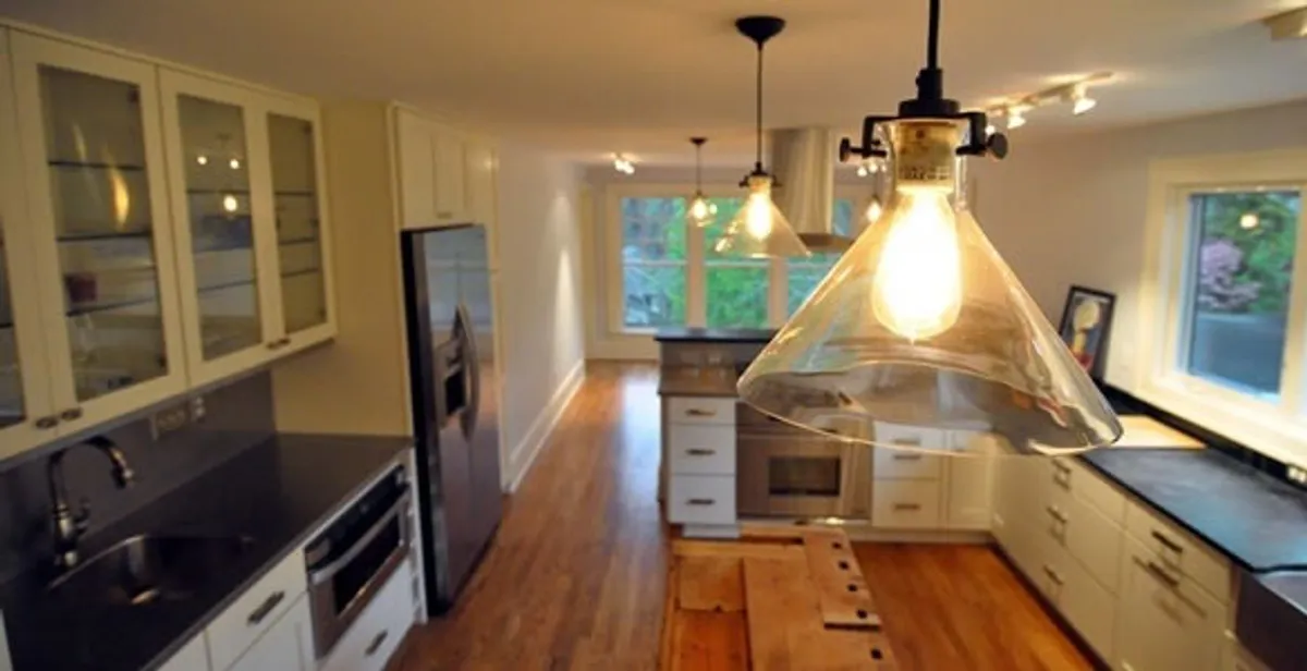 Residential electrician installing modern indoor light fixture in a home in Nashville, TN