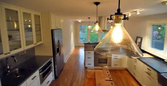 Residential electrician installing modern indoor light fixture in a home in Nashville, TN